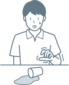 手足がけいれんしてコップを倒している男性