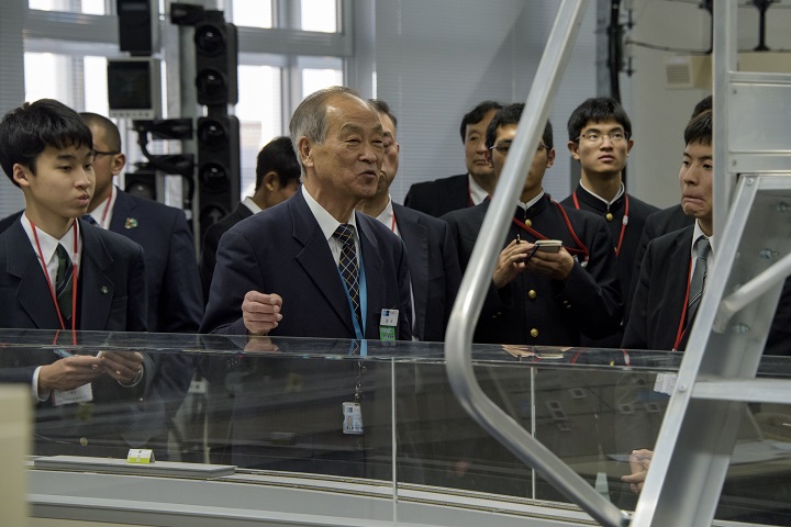 模型を使って訓練する施設で写真の説明を受ける生徒の写真