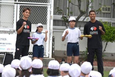 児童代表にバトンをプレゼントしてガッツポーズ