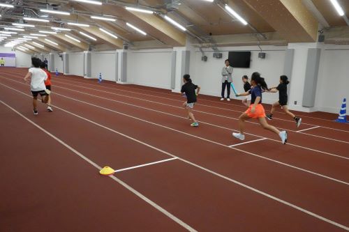 小学生がバトンパスの練習