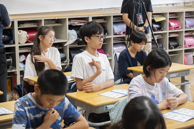  Elementary school children learning sign language with the booklet