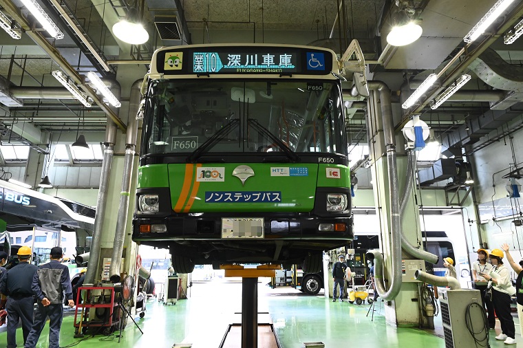 参加者が都営バスの下部分を見ている写真