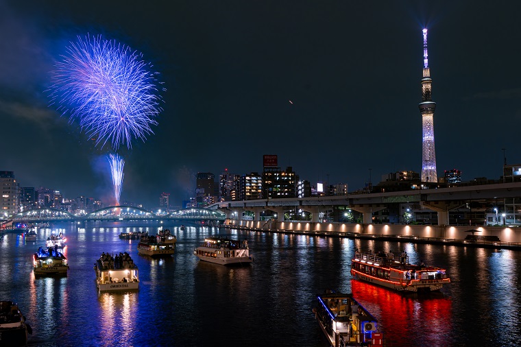 ライトアップされた東京スカイツリーと共演する隅田川の花火の写真