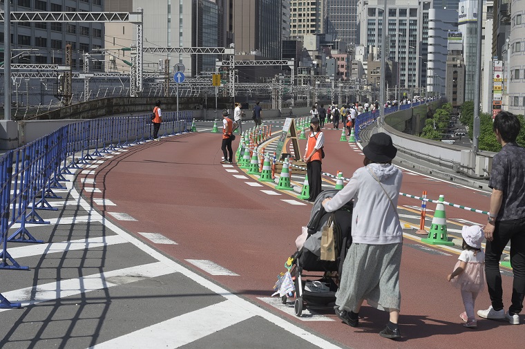 ベビーカーから降りて歩く家族の写真