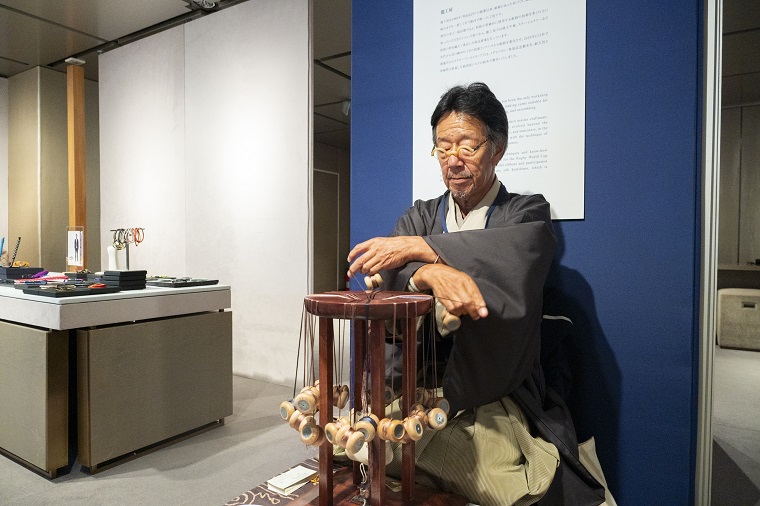 職人が組紐を組む実演の写真