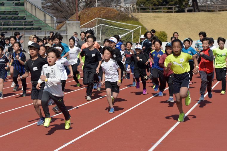 トラックを元気よく走りだす参加者の写真