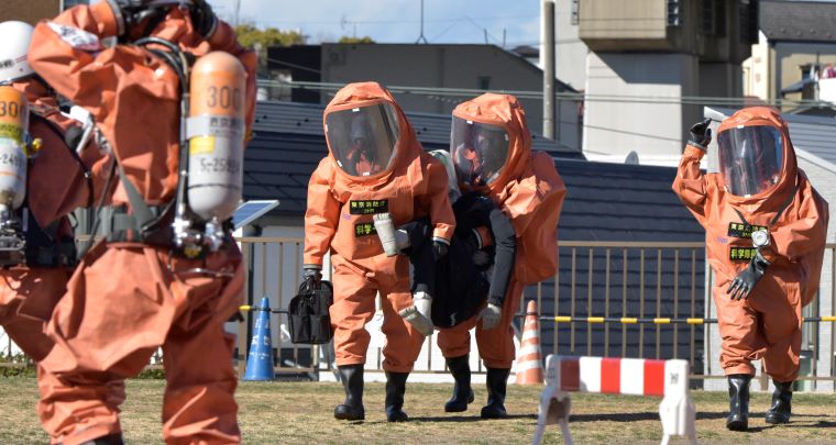 化学防護服を着て被災者を救出する訓練の写真