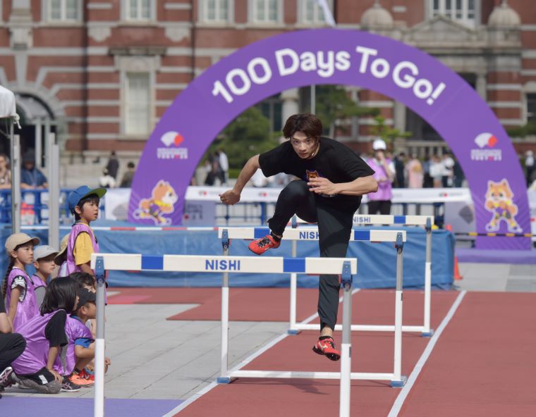 参加者の前で、ハードルを飛んで見せる金井大旺さんの写真