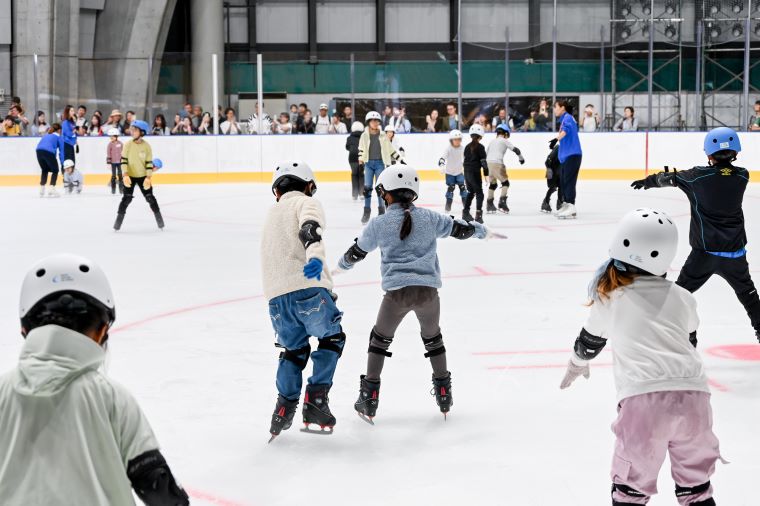 メインリンクで参加者がスケートを楽しんでいる写真