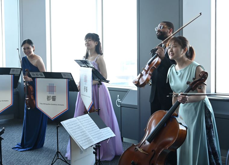 来訪者に挨拶をする演奏者４人の写真