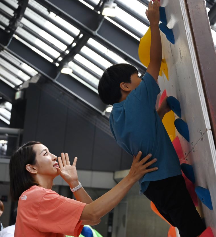野口啓代さんが子どもたちにスポーツクライミングの指導をする写真