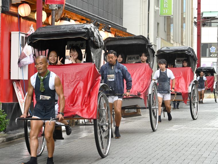 研修生が人力車の搭乗体験をする写真